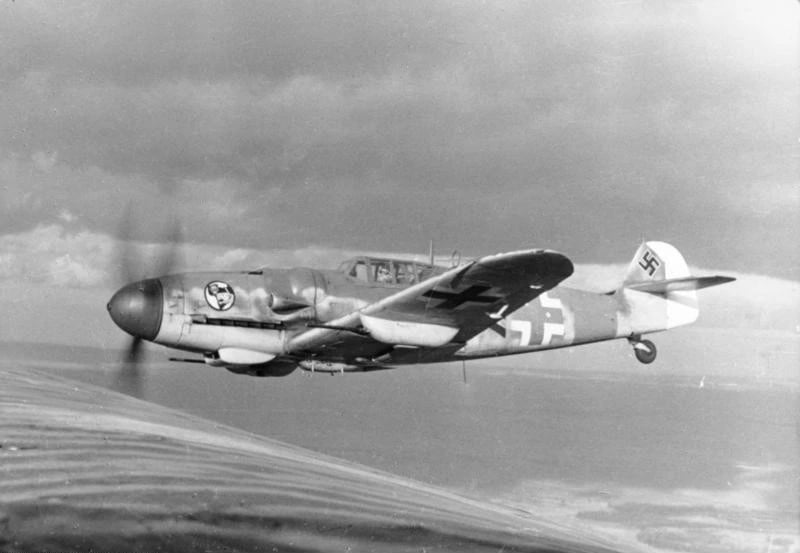 A wartime photograph of a Messerschmitt Bf 109 fighter of Jagdgeschwader 27 in flight, seen from the side.